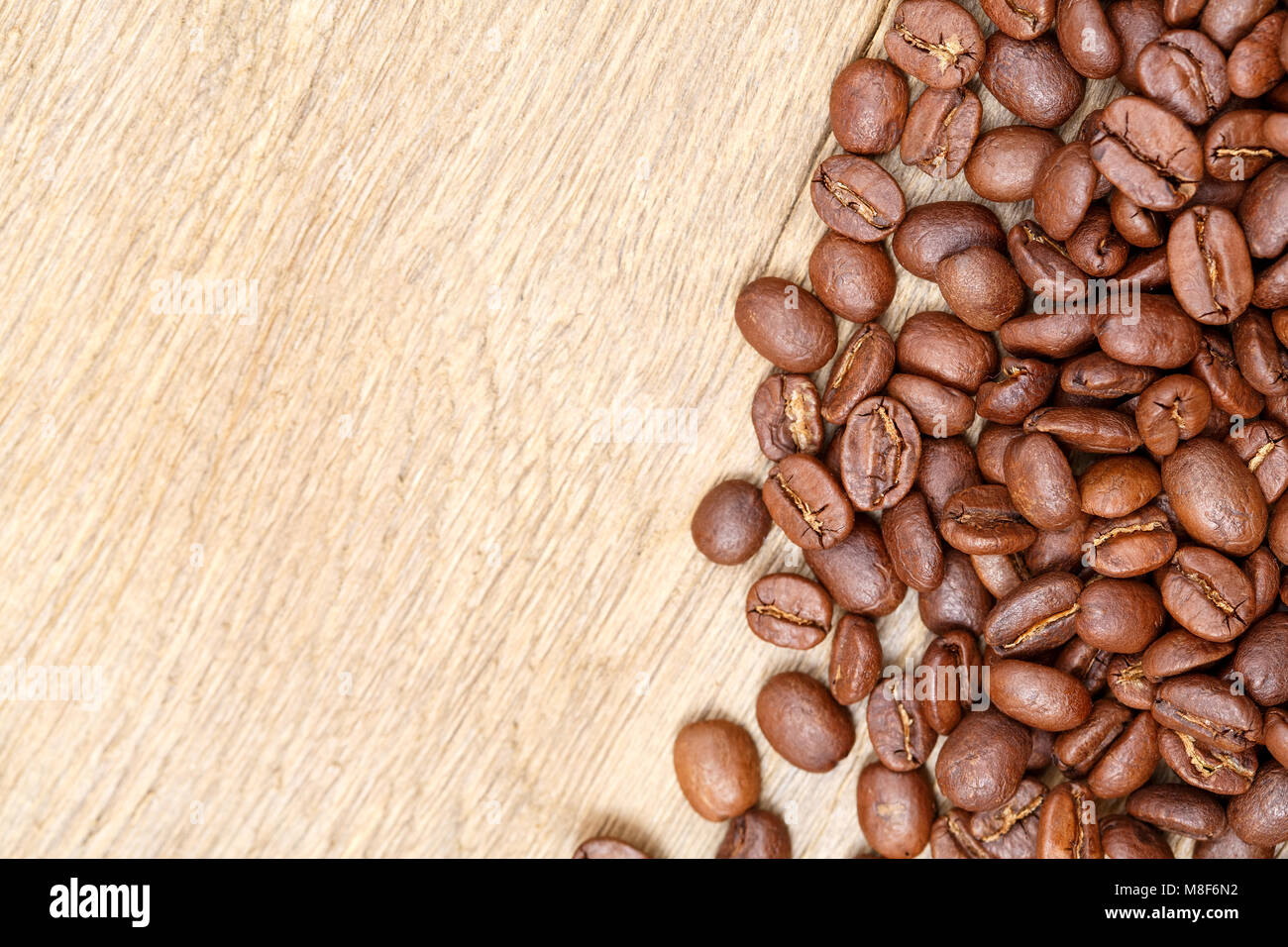 Chicchi di caffè tostati su un tavolo di legno. I chicchi di caffè. Foto Stock