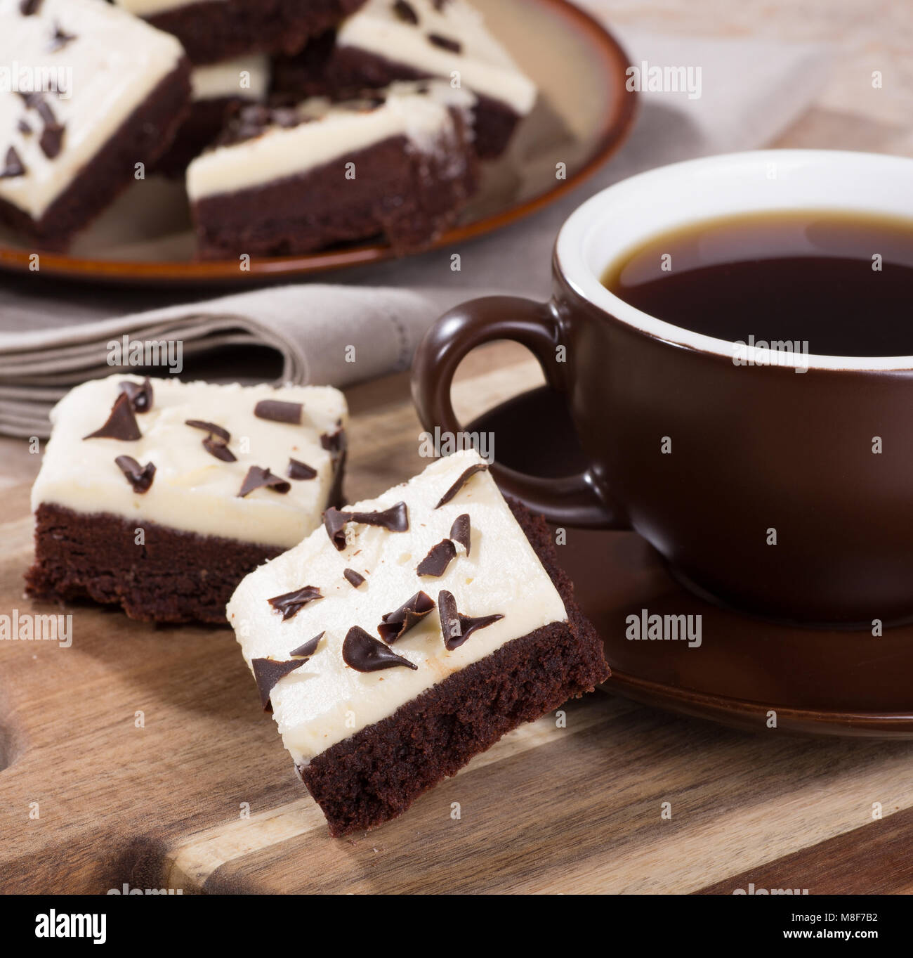 Due strati di cioccolato brownies con una tazza di caffè su un vassoio in legno Foto Stock