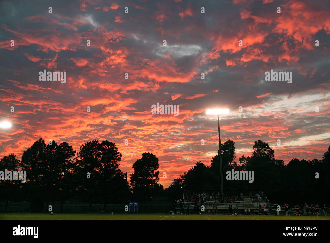 Venerdì sera il gioco del calcio al tramonto sotto le luci dello stadio. Foto Stock