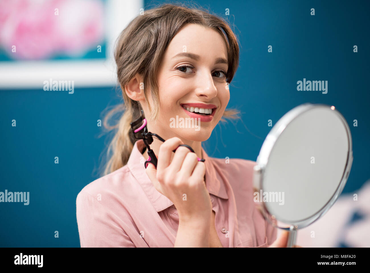 Donna che utilizza il bigodino di ciglia Foto Stock