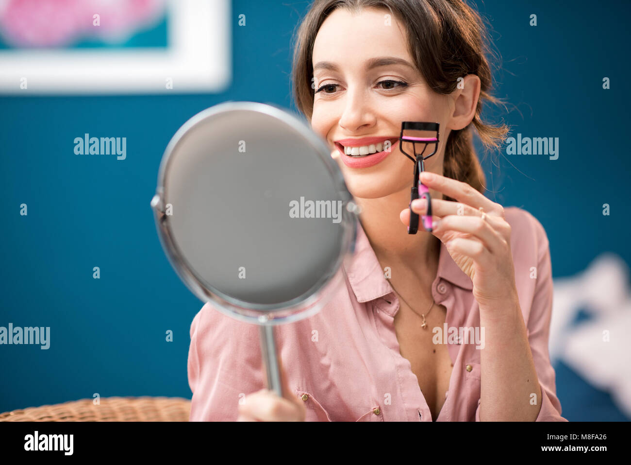 Donna che utilizza il bigodino di ciglia Foto Stock