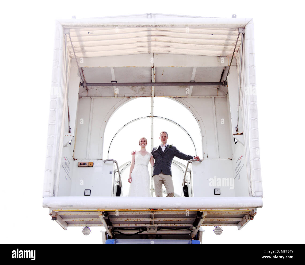 Appena una coppia sposata (Sposa e lo sposo) utilizzando airstairs a bordo di un aeroplano a volare sulla luna di miele. Modello rilasciato. Foto Stock