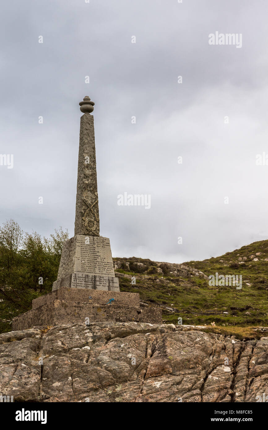 Shieldaig, Scozia - Giugno 10, 2012: Marrone obelisco di pietra come WW2 Memoriale di guerra lungo il Loch Shieldaig. Cielo grigio e verde collina nel retro. Foto Stock