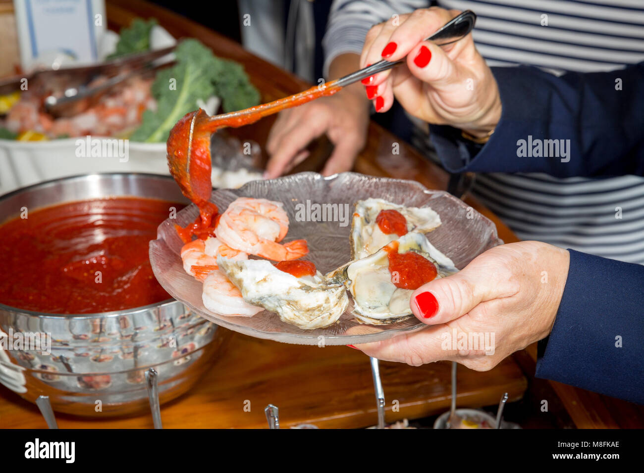 Donna incavature di frutti di mare a uno Yacht Club brunch, Naples, Florida, Stati Uniti d'America Foto Stock