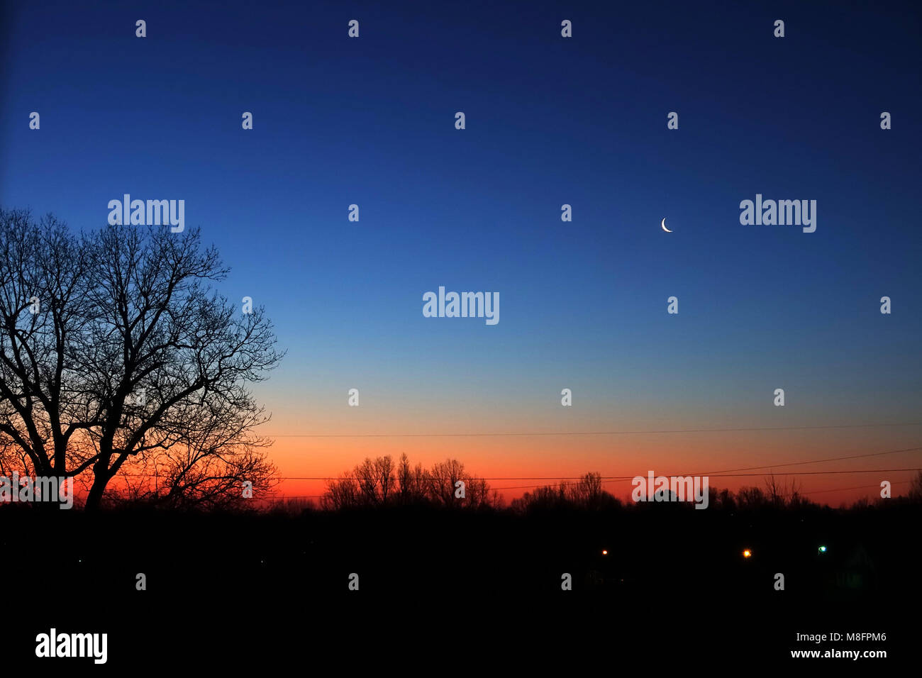 Rottura del giorno prima del sorgere del sole con una falce di luna ancora visibile. Foto Stock