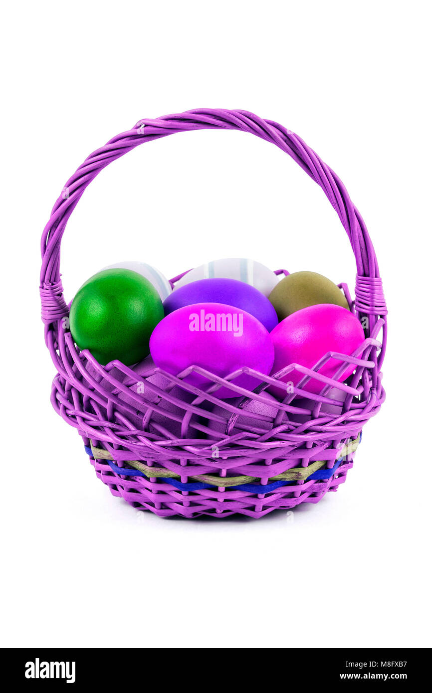 Uova di Pasqua in un cesto su sfondo bianco Foto Stock