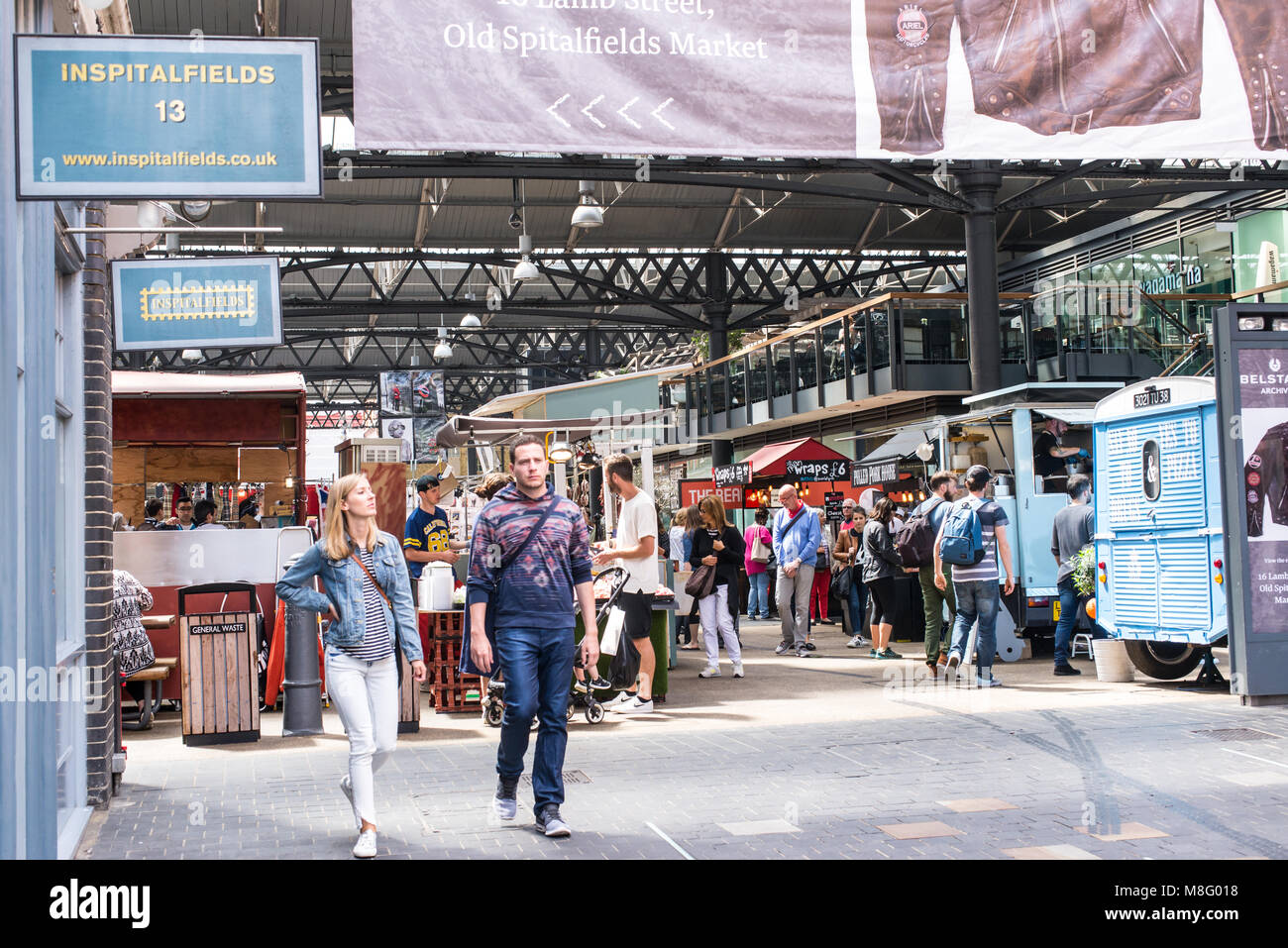 People Shopping e passeggiando per le bancarelle in Old Spitalfields mercato coperto. Spitalfields, East London, Regno Unito Foto Stock