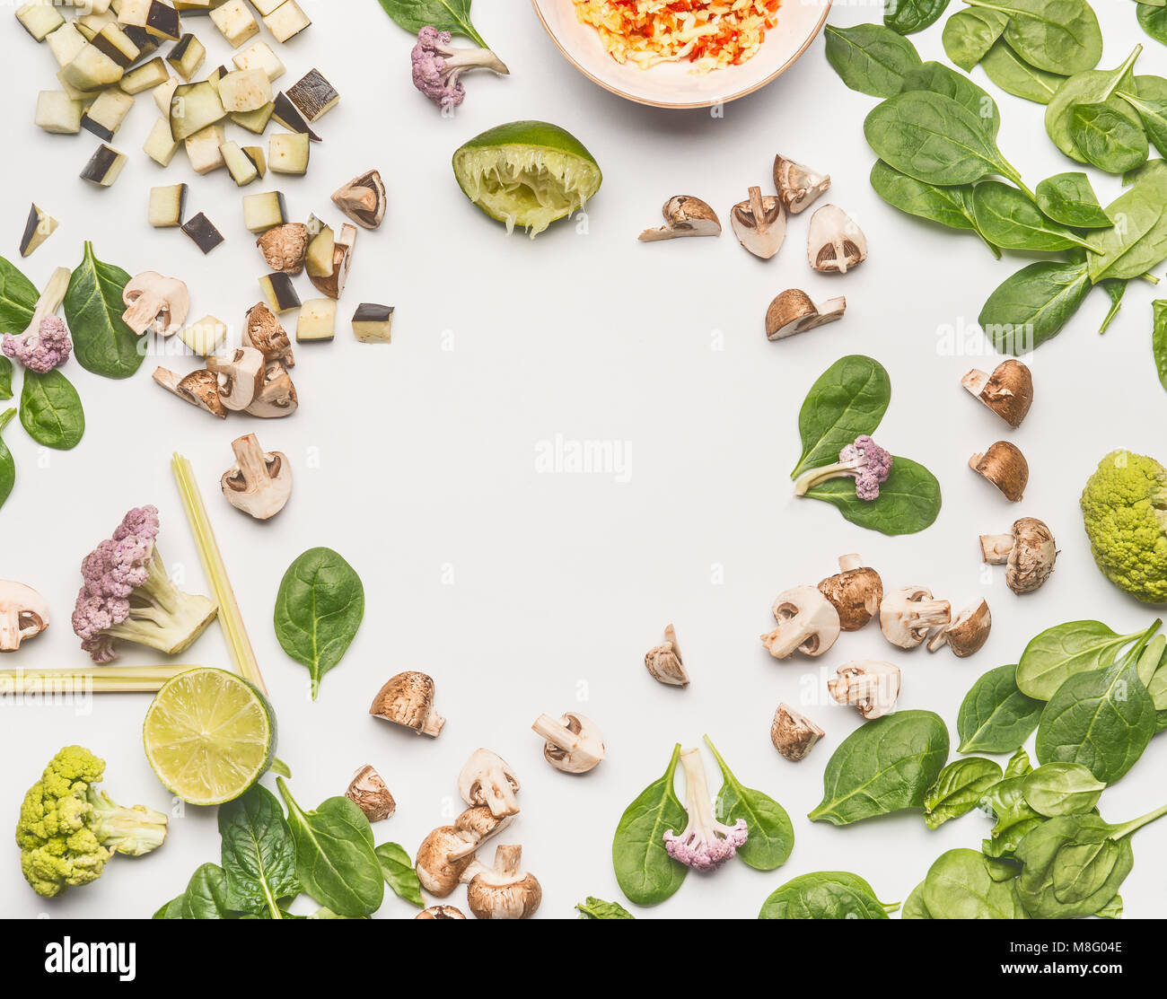 Cibo laici piatto con gli spinaci tritati funghi champignon, limone e verdure su sfondo bianco, telaio, vista dall'alto con spazio di copia Foto Stock