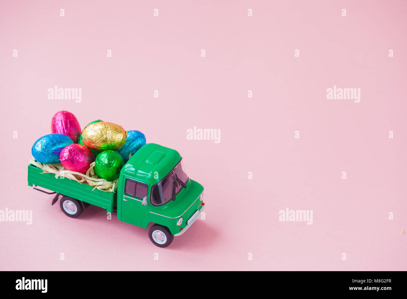 Verde giocattolo di prelievo che porta uovo di pasqua cioccolatini. Foto Stock
