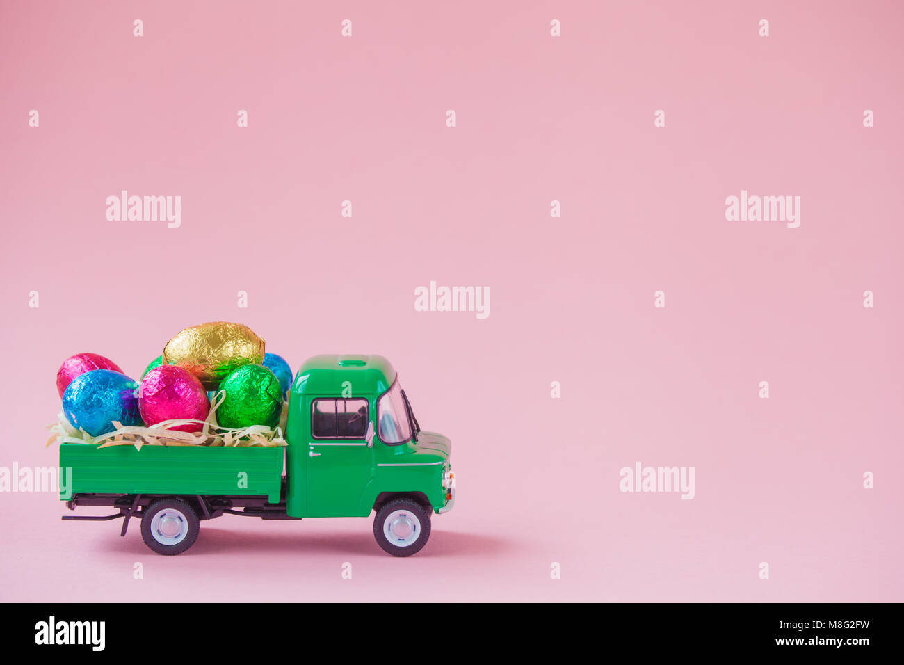 Verde giocattolo di prelievo che porta uovo di pasqua cioccolatini. Foto Stock