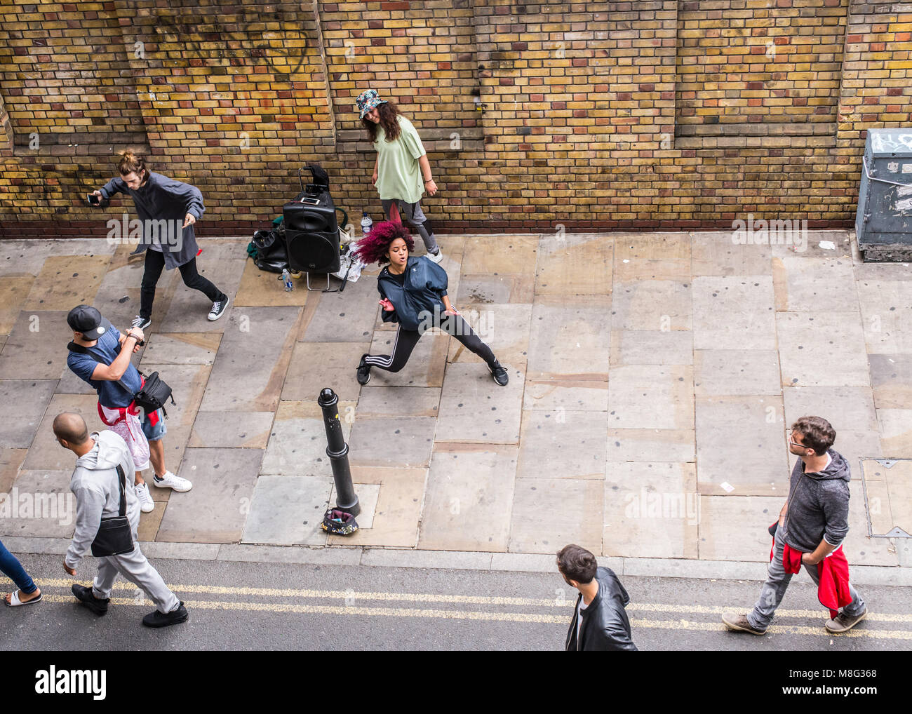 Street dance performance improvvisata da hip-hop ballerini acrobatici e guardare la gente al di fuori del Vecchio Truman Brewery, Ely's Yard, Shoreditch, Londra, U Foto Stock