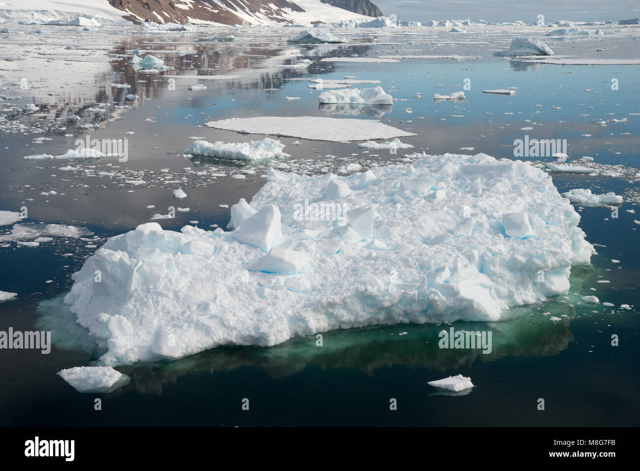 Un piccolo iceberg galleggianti in mare cristallino in Antartide Foto Stock