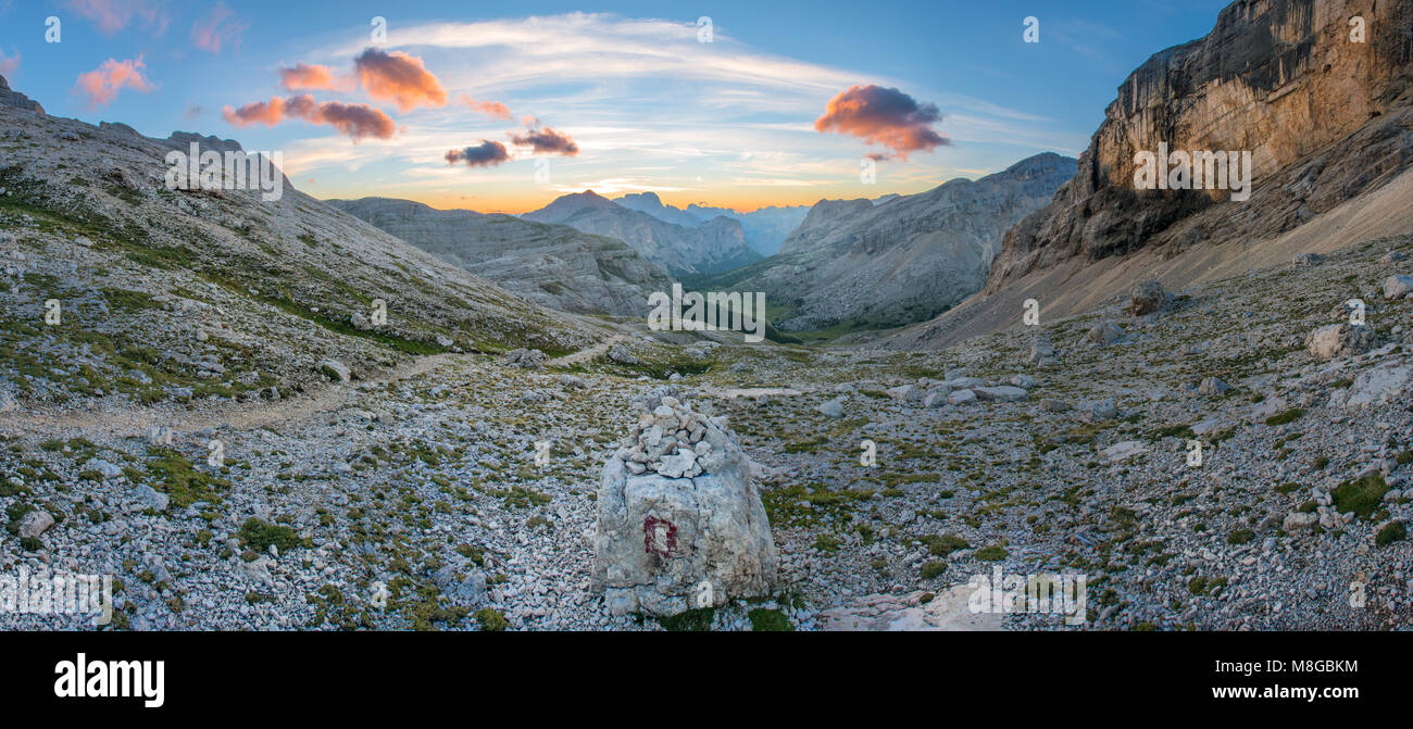 Splendido dipinto di cielo, nuvole come il sole viene fuori da dietro le montagne all'orizzonte. Sunrise nelle Dolomiti, le alpi del Nord Italia. Foto Stock