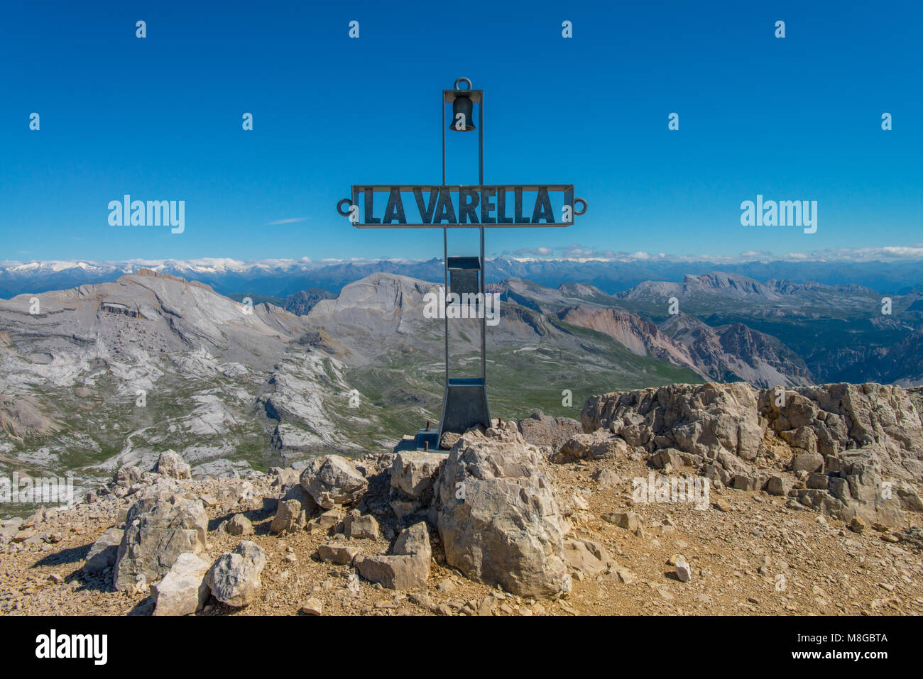 La croce di vetta del La Varella, con sullo sfondo le Alpi e la valle di Fanes park . Montagne dalle vette innevate in estate in montagna. Foto Stock