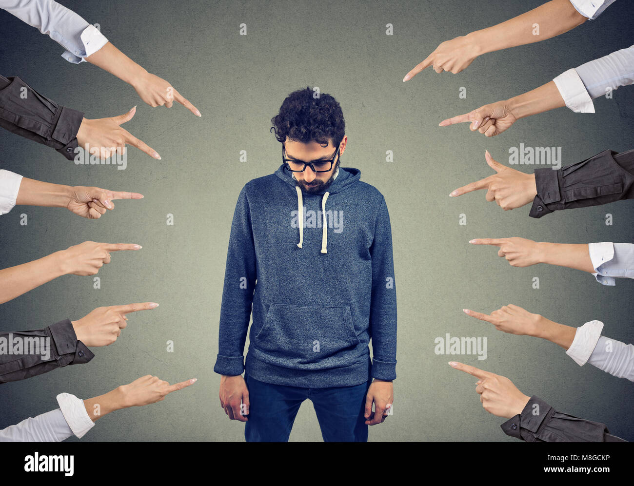 Abbondanza di raccolto dita di mani puntando al giovane uomo di sentirsi colpevole ed essendo introverso. Foto Stock