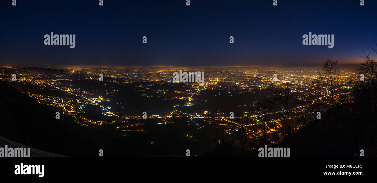 Luci della città dalla cima del Monte Grappa. Inquinamento luminoso proveniente dalla città e dalla pianura sottostante. La fotografia notturna. Foto Stock