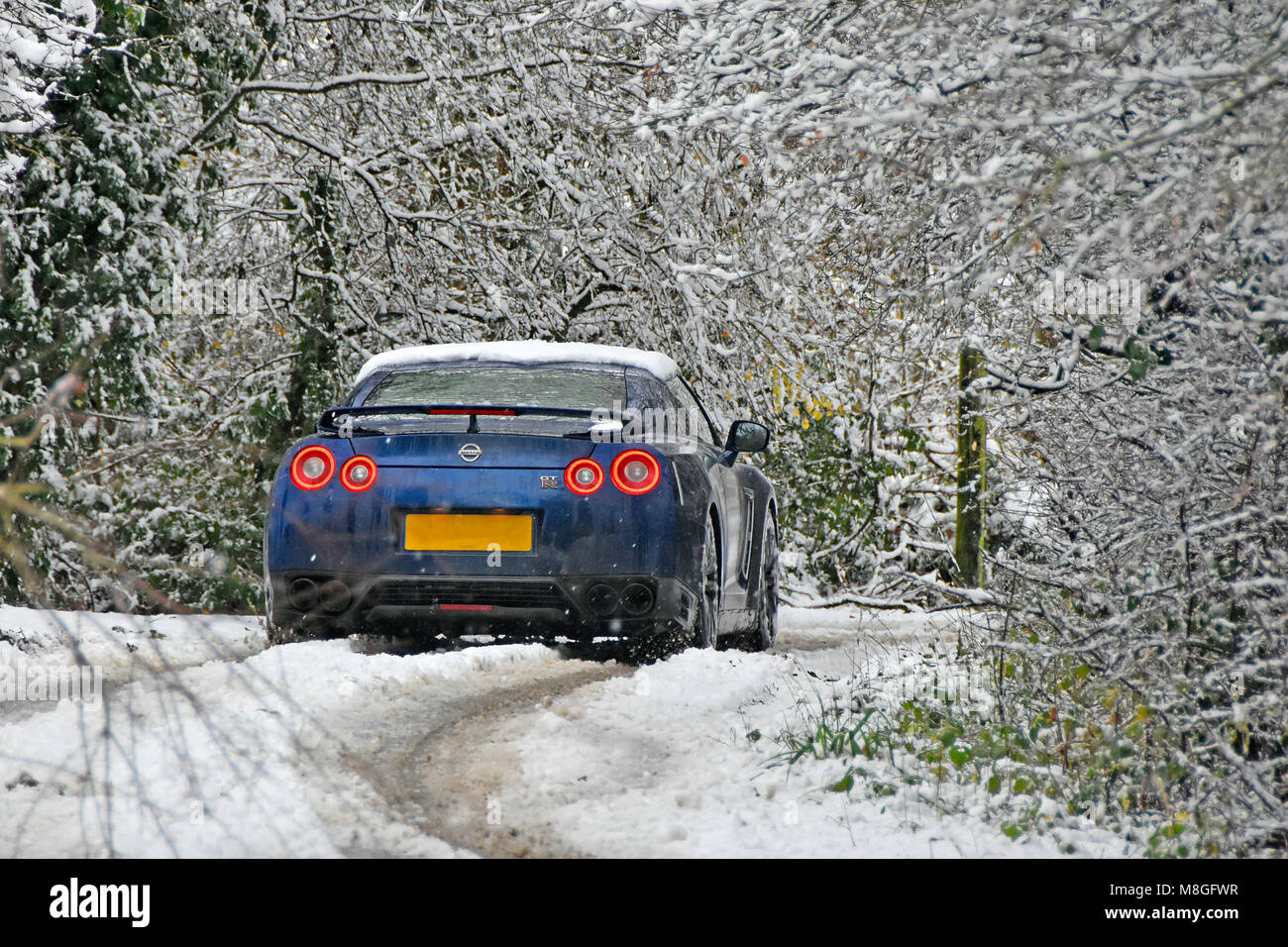 Albero innevato paesaggio guida scena auto nella strada stretta verso il vicolo del paese coperto in inverno neve caduta rural home counties freddo England Regno Unito Foto Stock