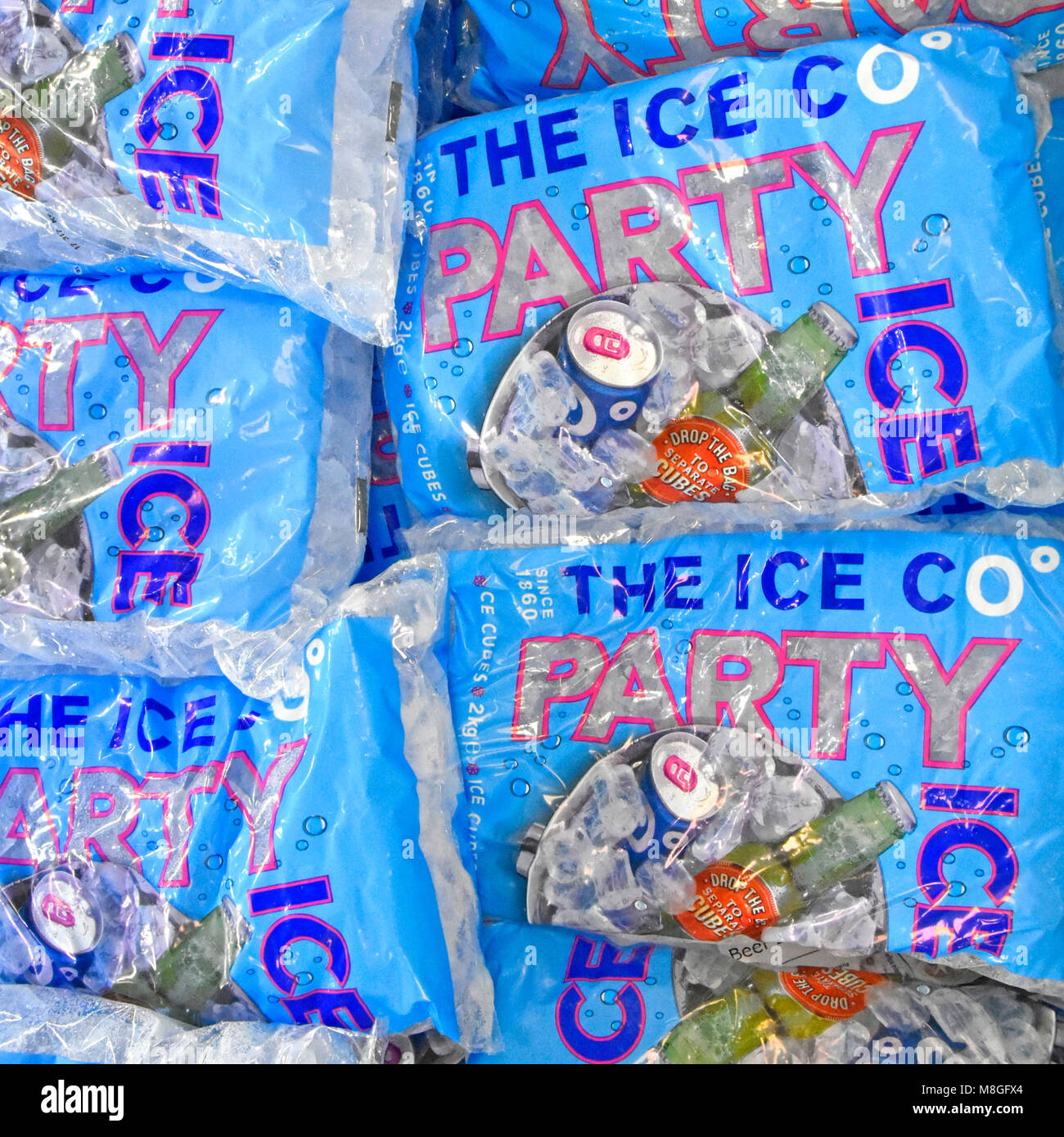 Imballaggio per il cubo di ghiaccio per raffreddare le bevande vendute in sacchetti di plastica di cubetti di ghiaccio per le parti e per uso domestico venduti dal frigocongelatore da supermercato England Regno Unito Foto Stock