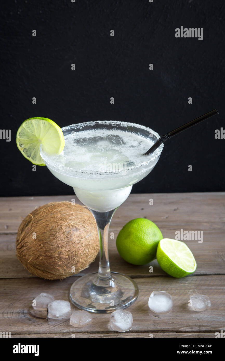 Noce di cocco Сocktail Margarita con calce scuro sul tavolo di legno, copia dello spazio. Bianco o Margarita Daiquiry Cocktail. Foto Stock