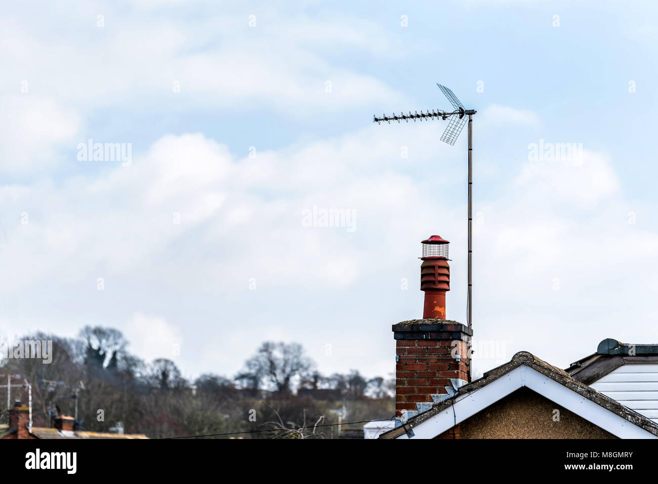 Inglese ciminiera in mattoni e antenna TV sulla luce bella cielo blu Foto  stock - Alamy