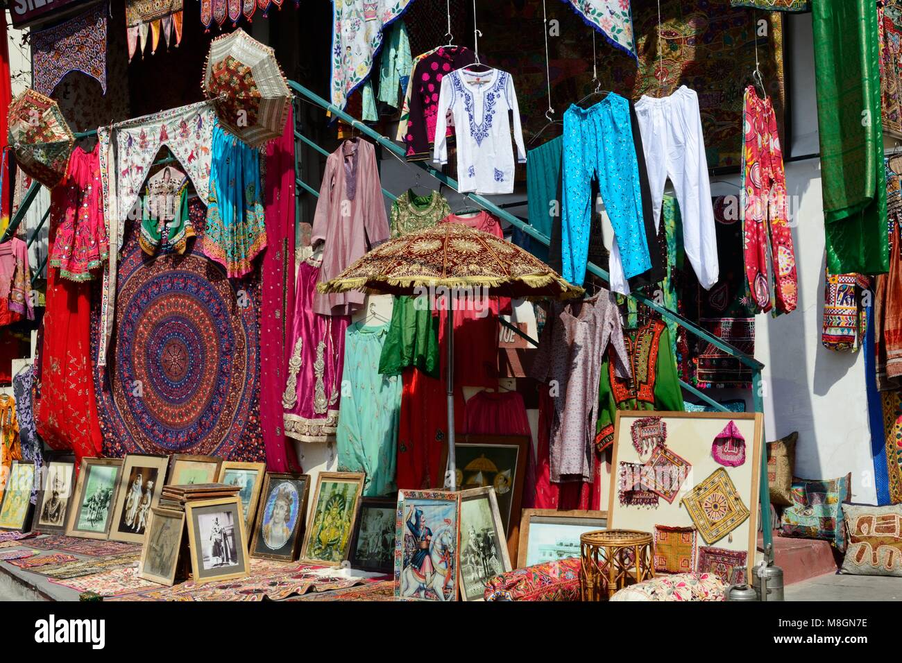 Variopinti tessuti indiani abbigliamento e artigianato visualizzata a lato strada shop Udaipur Rajashan india Foto Stock