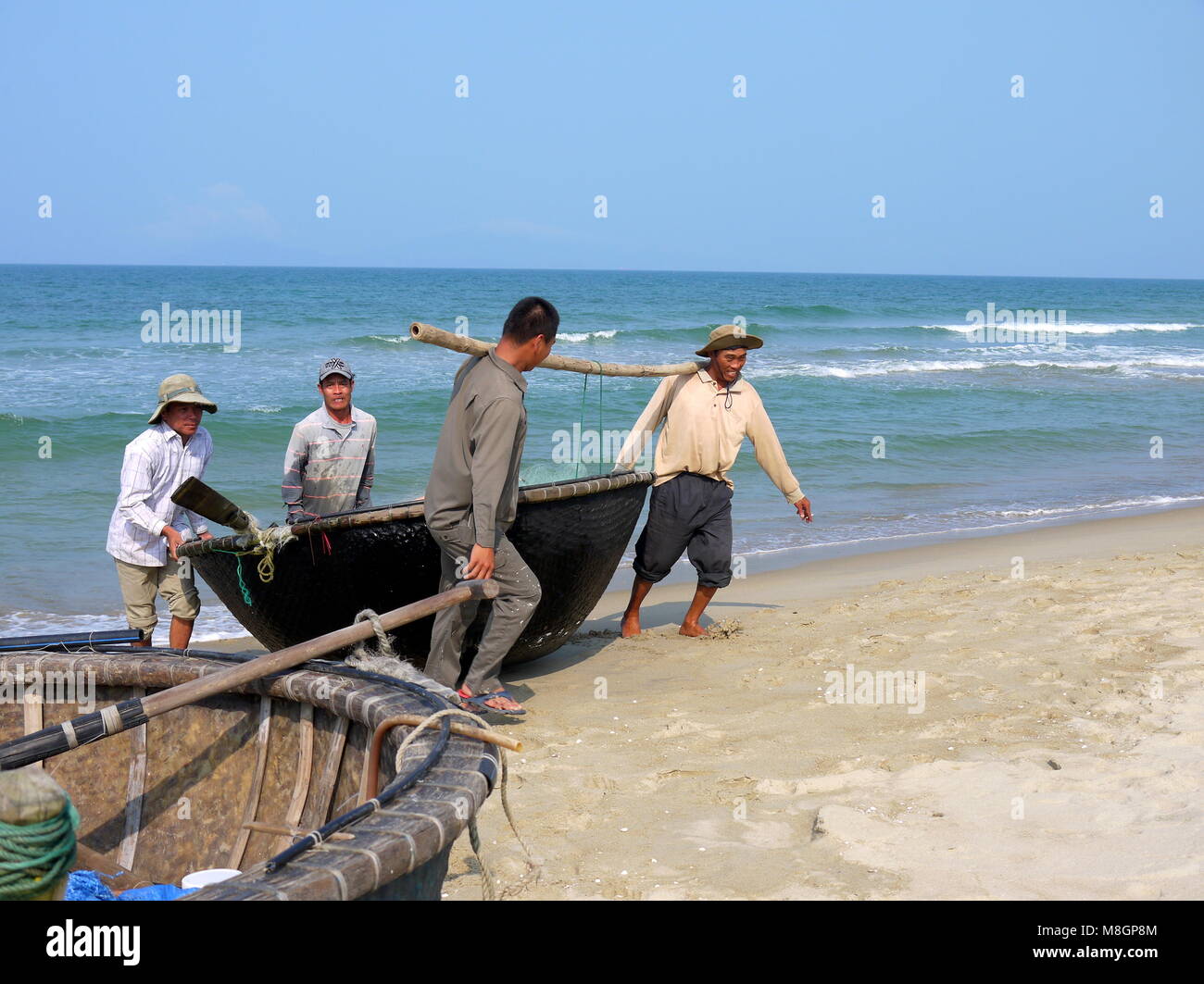 Hoi An, Da Nang, Vietnam - MARZO 16, 2018: i pescatori di ritorno dalla pesca con tradizionale vietnamita barca rotonda su una bella giornata in spiaggia Foto Stock