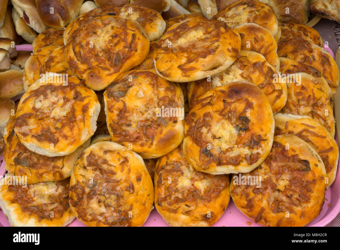 Mini-pizze accumulate su una tavola di legno sfondo Foto Stock