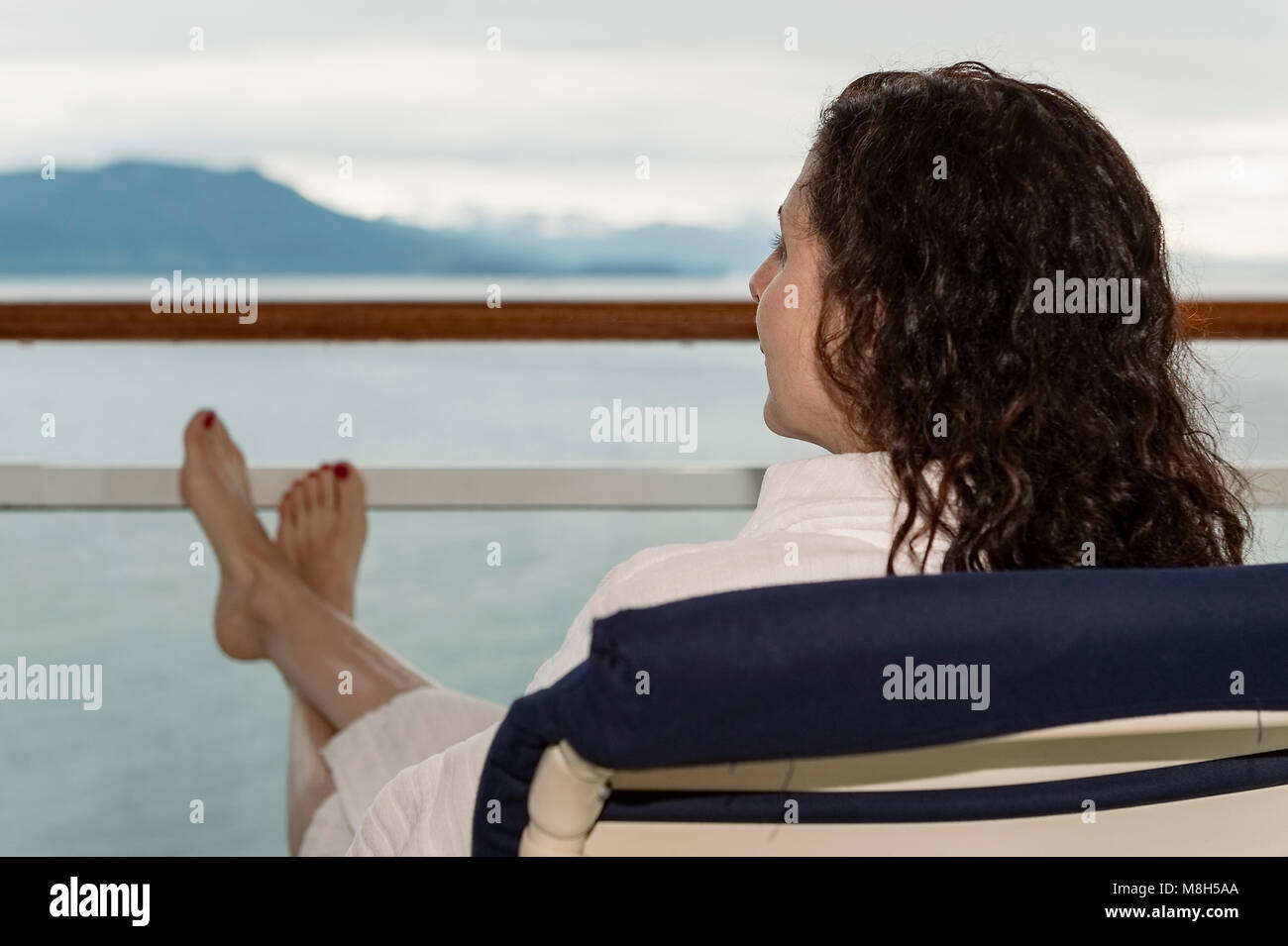 Donna godendo la vista dalla sua nave da crociera balcone. Foto Stock