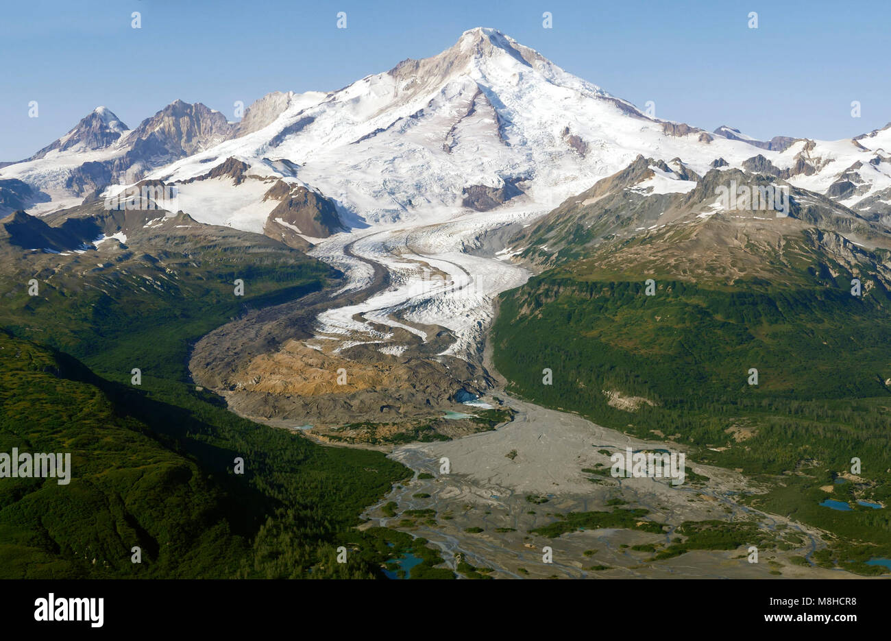 Vulcano Iliamna. Un ghiacciaio fluisce fuori dal vulcano Iliamna verso una vasta pianura dilavamento lungo il fiume Johnson in questa antenna Foto Stock