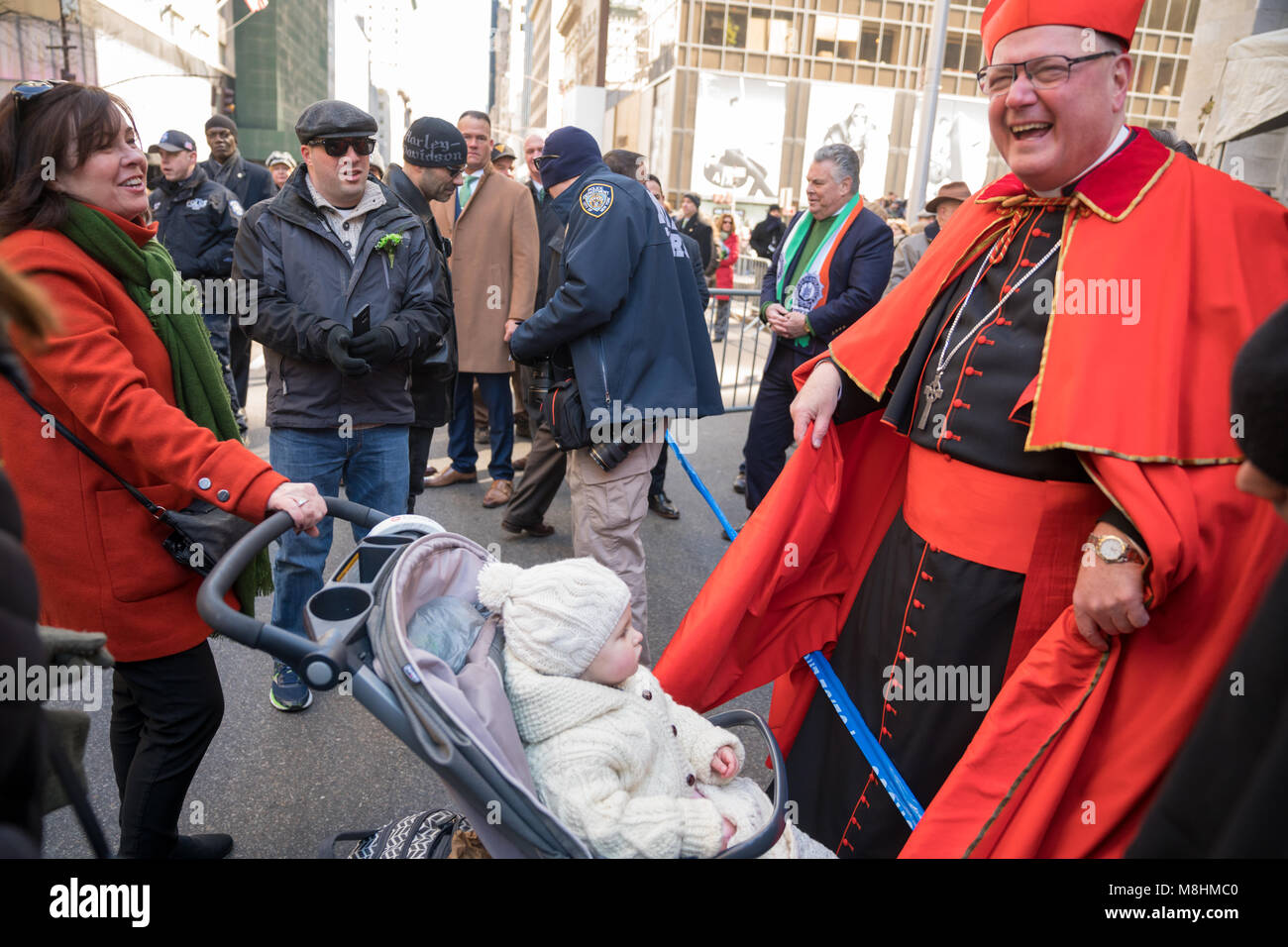 New York, Stati Uniti d'America, 17 Mar 2018. Arcivescovo di New York il Cardinale Timothy Dolan saluta un bambino di fronte la Cattedrale di San Patrizio durante la tradizionale festa di San Patrizio Parade. Foto di Enrique Shore/Alamy Live News Foto Stock