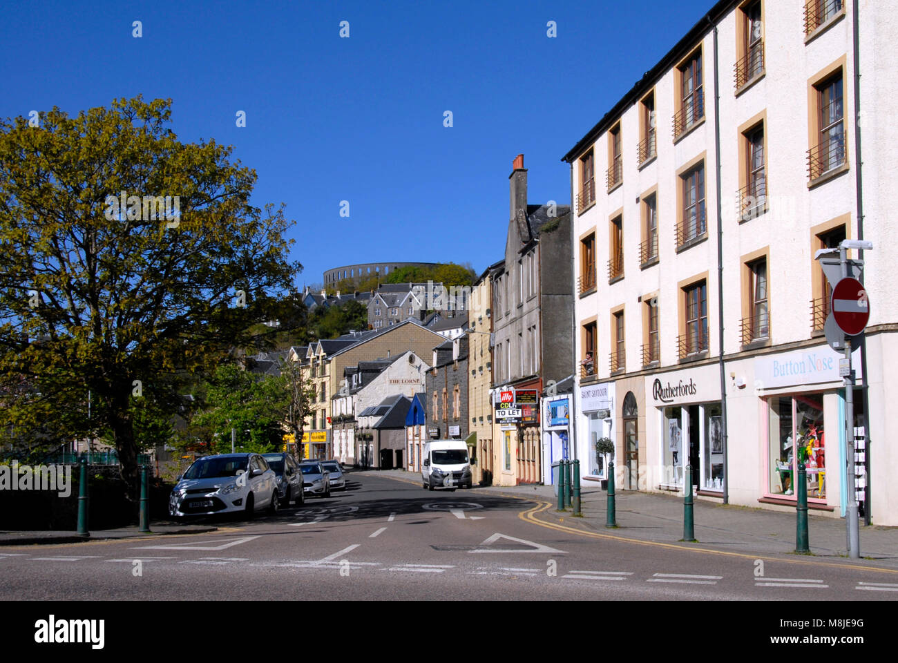 Stevenson Street, Oban, Scozia, con McCaig's Tower in background Foto Stock