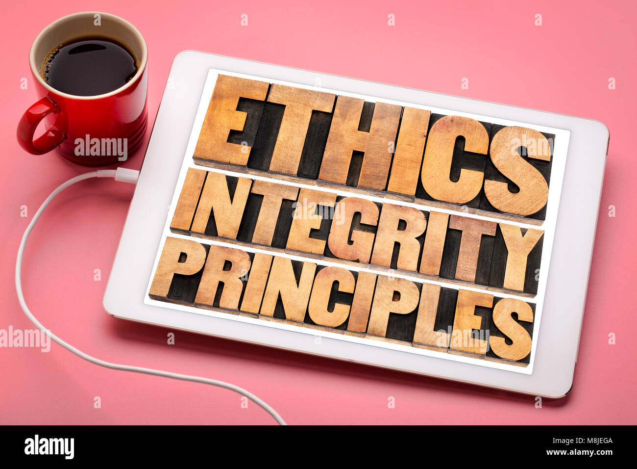 Etica e integrità e di principi astratti di parola - concetto etico su una tavoletta digitale con una tazza di caffè Foto Stock