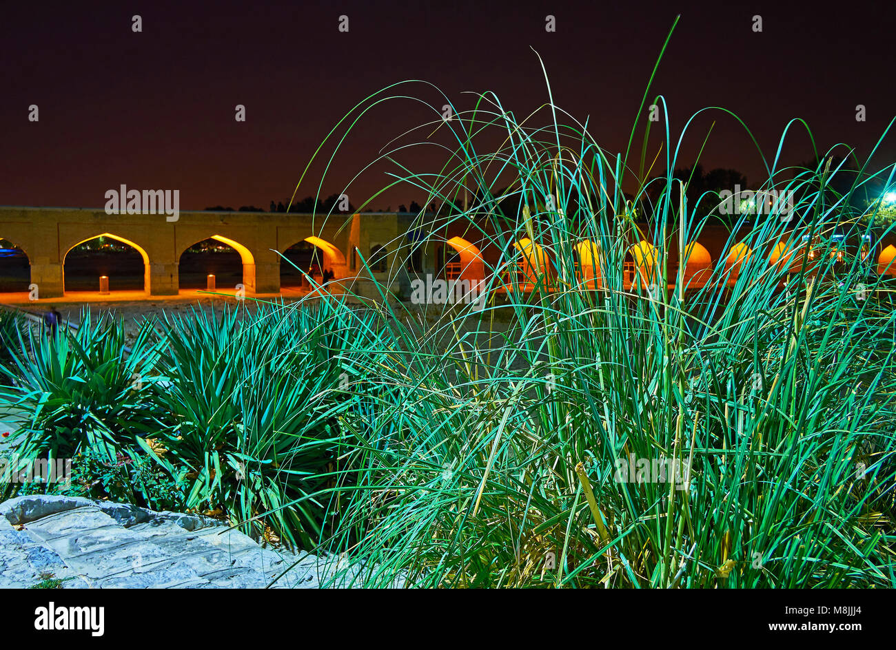 La lussureggiante vegetazione di Moshtagh-e Aval park nasconde la bella Joui arcuata bridge, Isfahan, Iran. Foto Stock