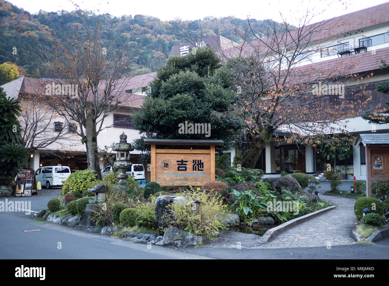 Ragazza seduta all'entrata frontale dell'Hotel Yoshiike Foto Stock