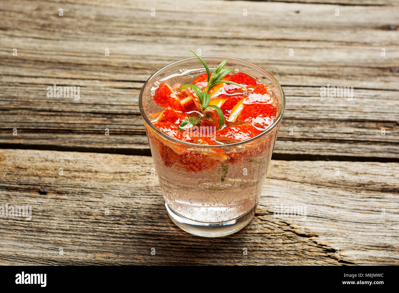 Cocktail di rosso con rosmarino e Arancio sanguigno pezzi, il fuoco selettivo Foto Stock