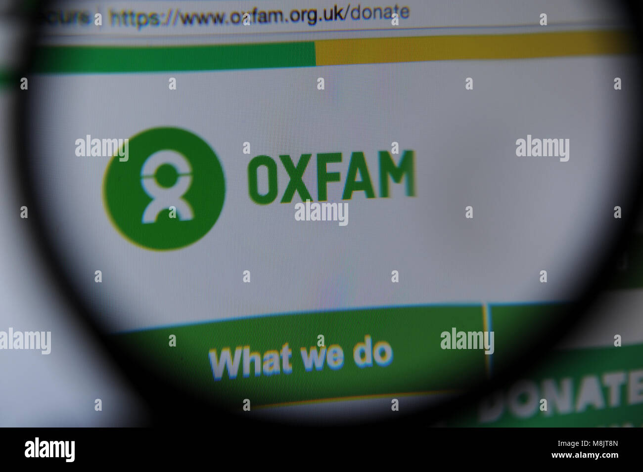 Il sito web Oxfam visto attraverso una lente di ingrandimento Foto Stock