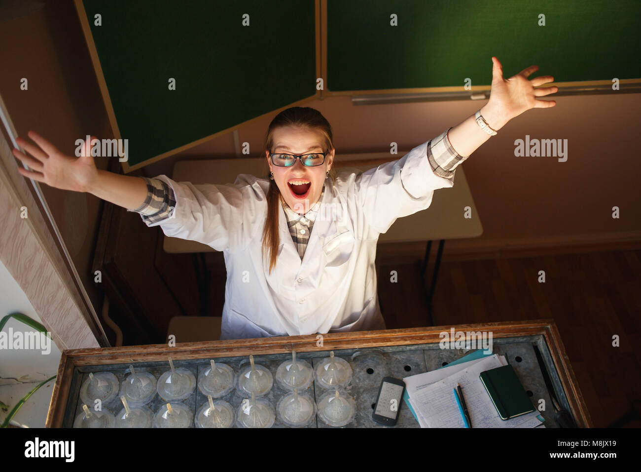 Felice donna scienziato sollevando le mani nel suo laboratorio Foto Stock
