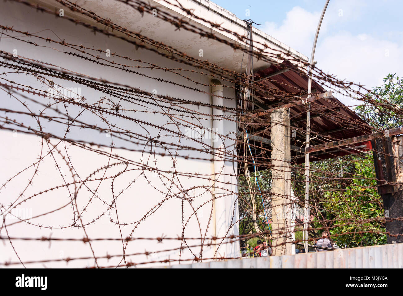 Filo spinato filo spinato e recinzione electricified intorno al perimetro del Museo del Genocidio Tuol Sleng, Phnom Penh, dove i Khmer rossi, sotto la guida di Pol Pot, torturati migliaia di persone prima che la loro uccisione. Foto Stock