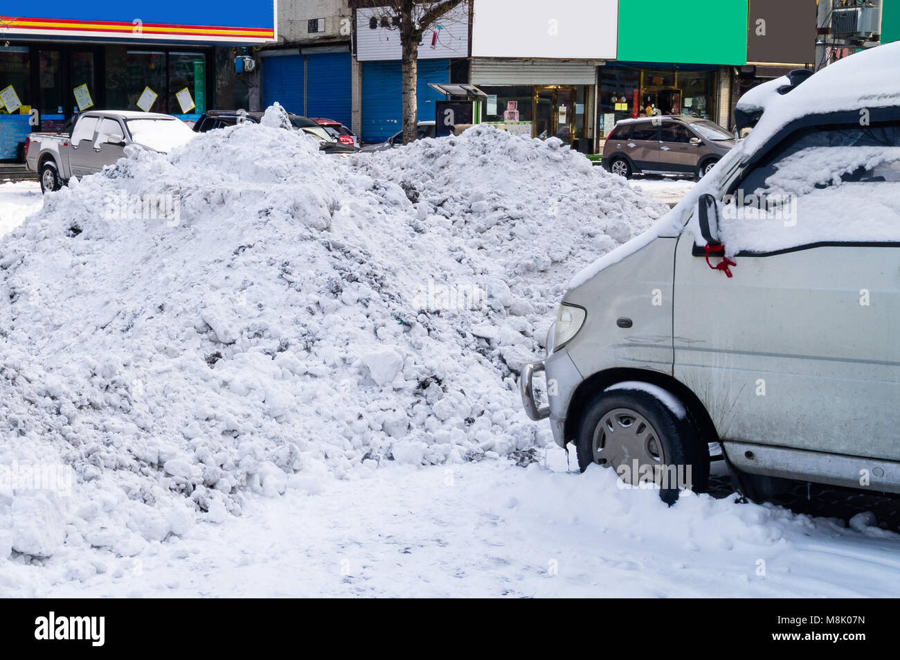Le conseguenze della nevicata e rimozione della neve sulle strade della città. Derive sulla carreggiata e parcheggi. Cumuli di neve sulle vetture Foto Stock