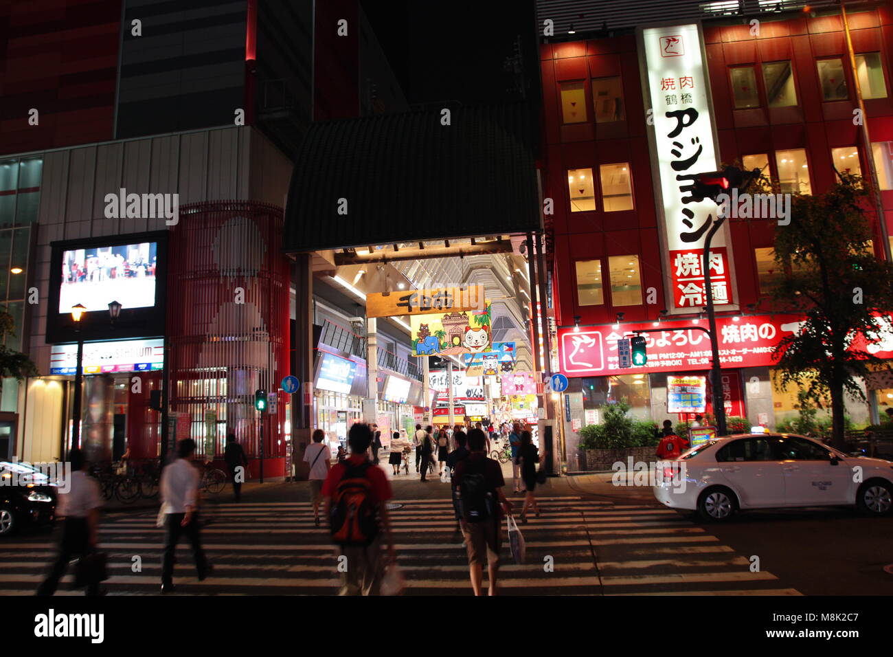 I turisti al semaforo svincolo per Osaka Shinsaibashi strada dello shopping di notte. Shinsaibashi è una popolare destinazione per lo shopping di Osaka in Giappone. Foto Stock