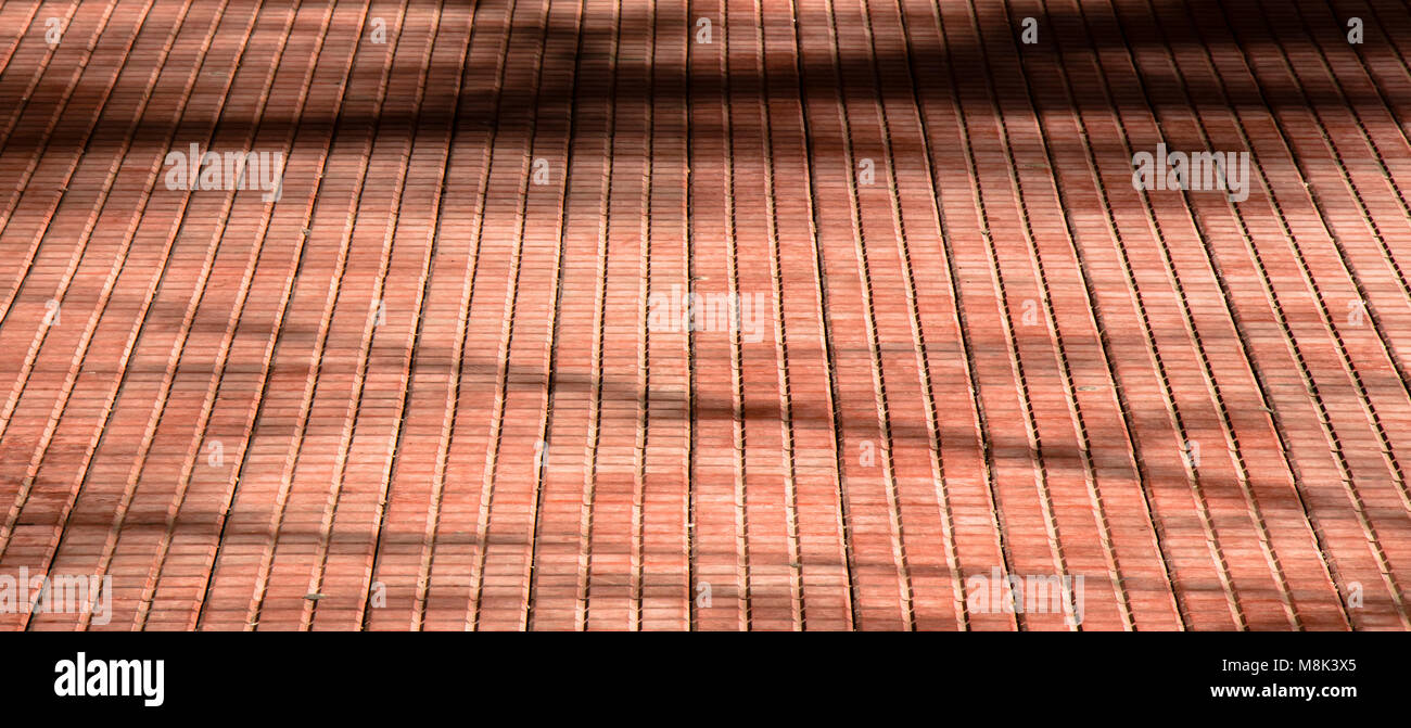Dettaglio di un pavimento per esterni con tegole rosse e le ombre di albero Foto Stock