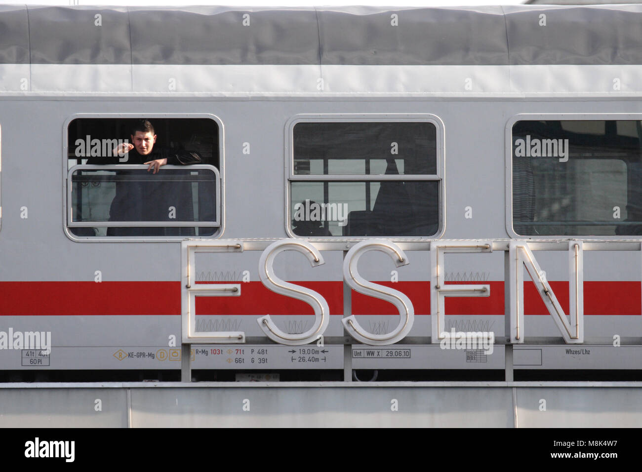 Bahn di Essen, in Germania. Un uomo sta guardando fuori della finestra. Direttamente di fronte al carrello è il nome della stazione di Essen Hauptbahnhof (stazione principale) Foto Stock