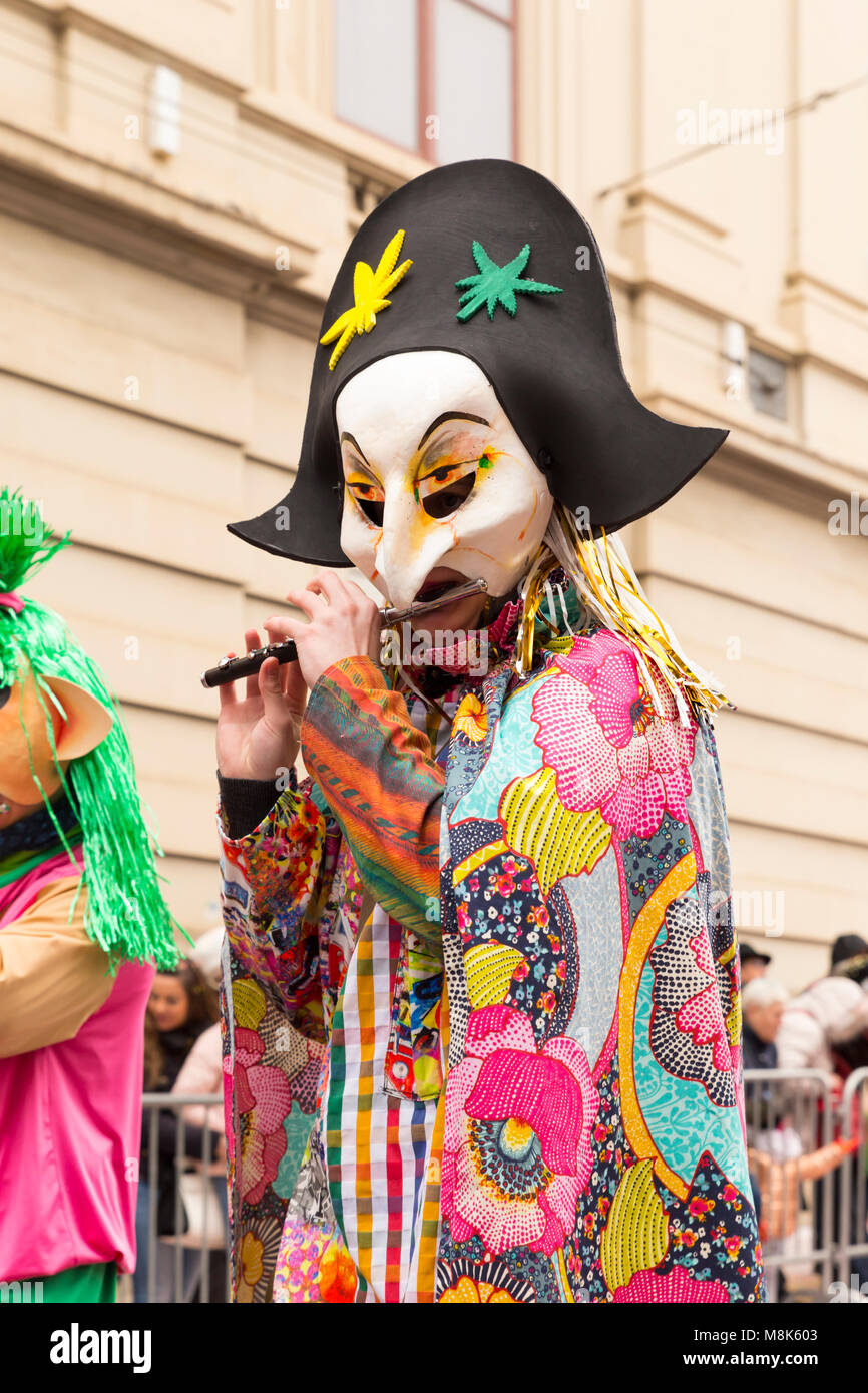Steinenberg, Basilea, Svizzera - Febbraio 19th, 2018. Ritratto di un singolo partecipante di carnevale in un colorato costume giocando piccolo flauto Foto Stock