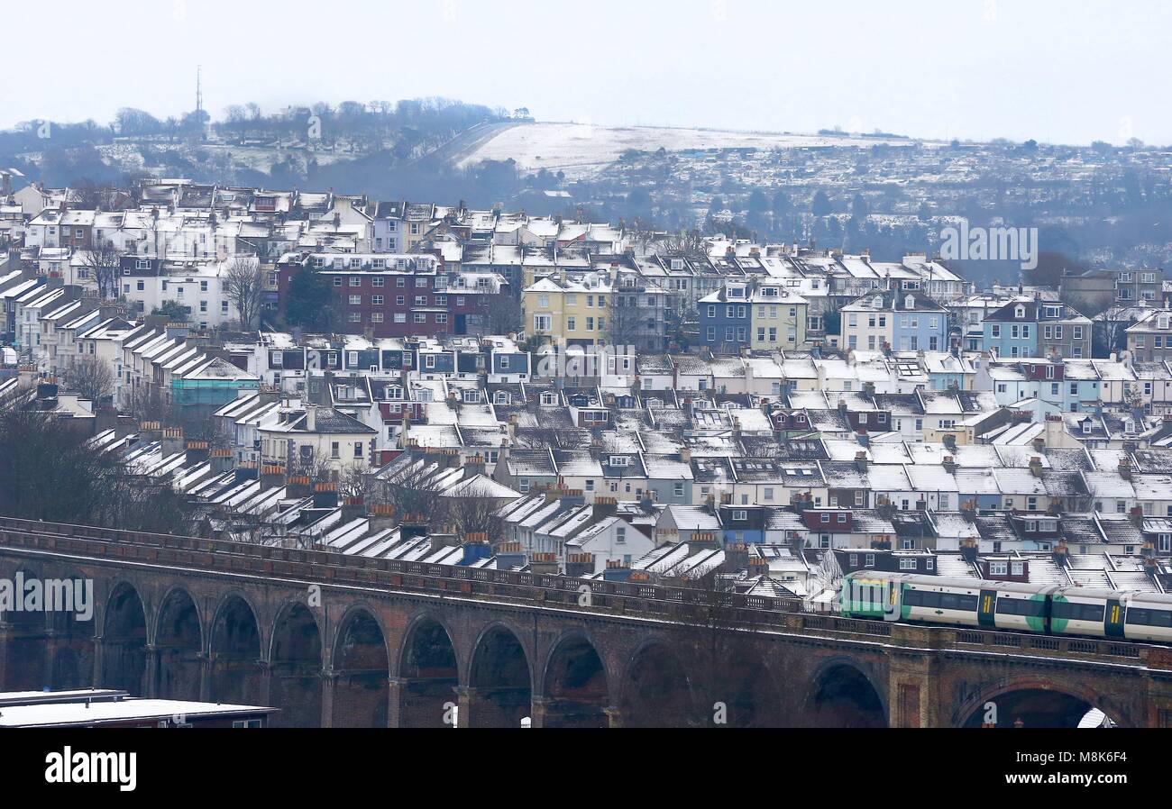 Coperta di neve case sono visti come un treno attraversa Londra viadotto stradale in Brighton.18 Mar 2018. Foto di James Boardman Foto Stock