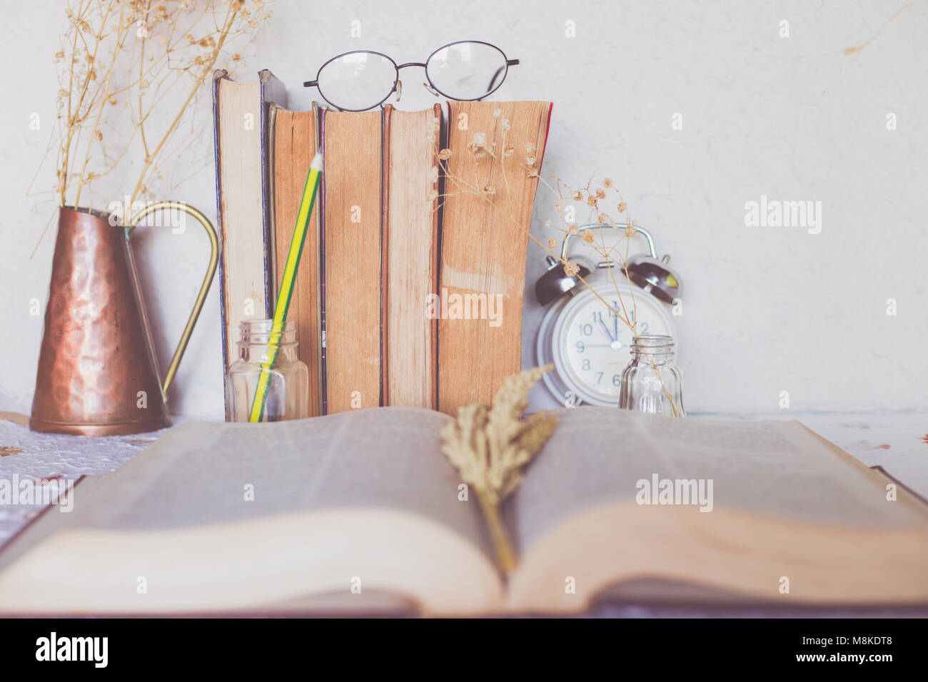 Fila di libri vecchi con gli occhiali da lettura sopra , annata del tono di colore Foto Stock