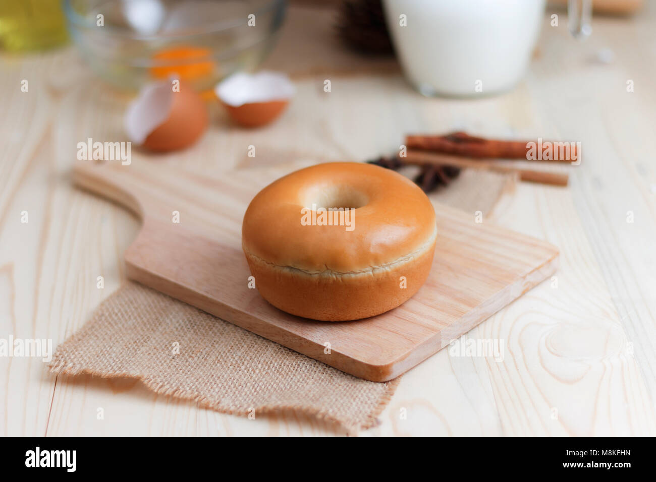 Home ciambella realizzato su legno taglio bordo con ingredienti di panificazione sul tavolo di legno selezionare focus leggera profondità di campo Foto Stock