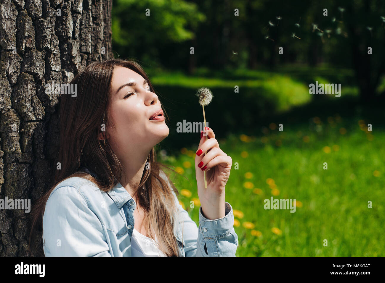 Bella giovane donna con il bianco tarassaco in posizione di parcheggio Foto Stock