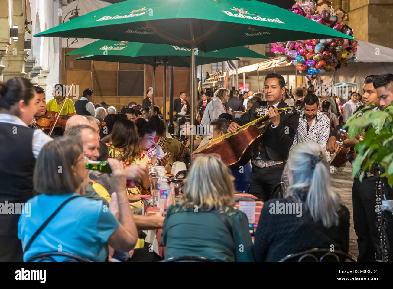 Oaxaca Oax., Messico - una banda Mariachi intrattiene diners presso un ristorante all'aperto sullo Zocalo (piazza centrale). Foto Stock