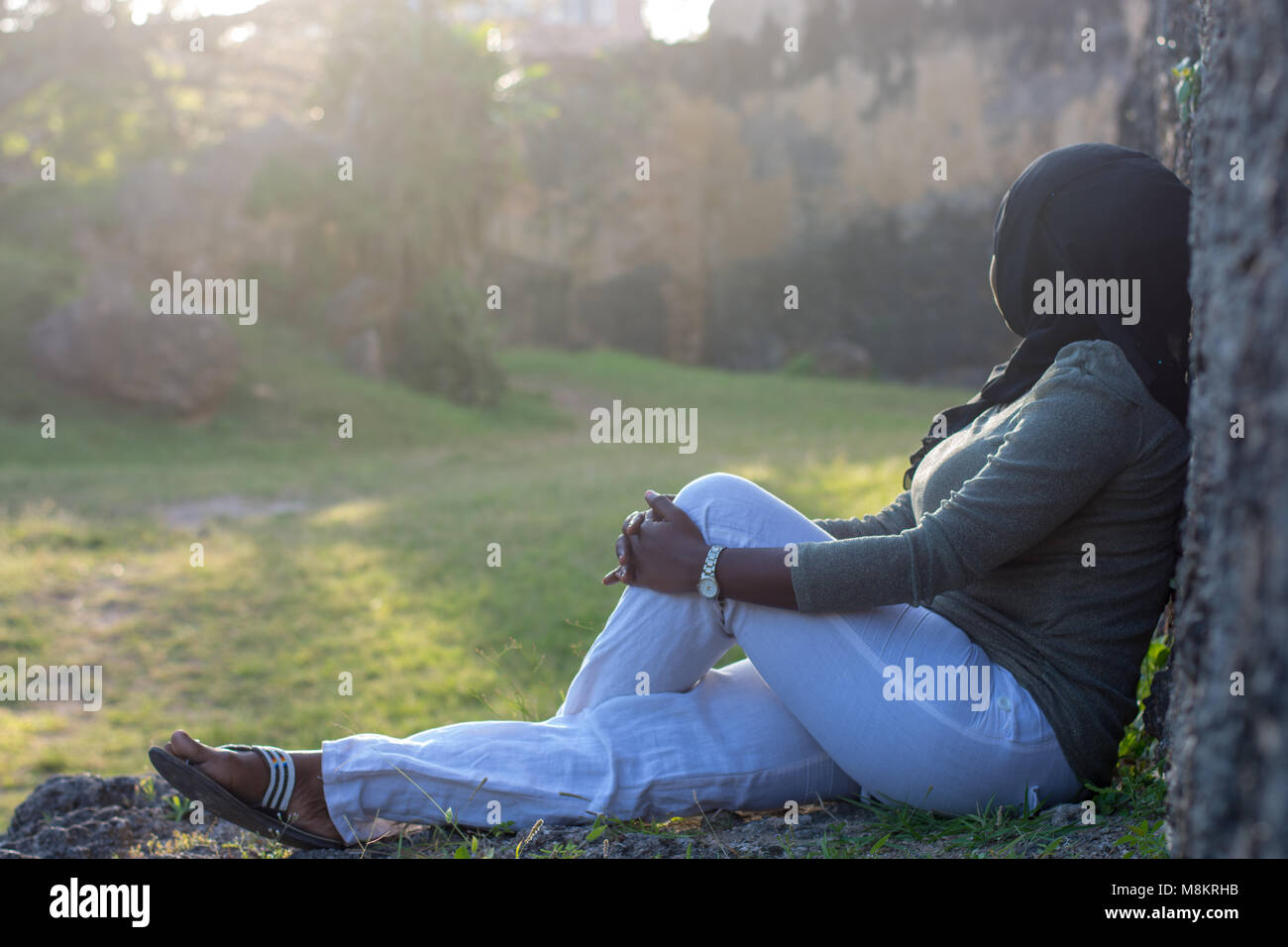 Signora appoggiata contro una parete Foto Stock