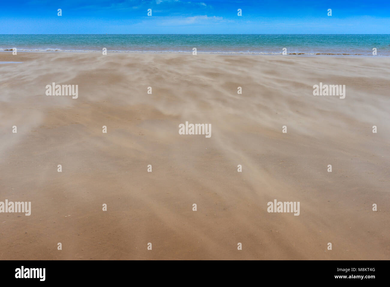 Il drifting sabbia fluisce verso il mare in una giornata di vento presso la località balneare di Bridlington Foto Stock